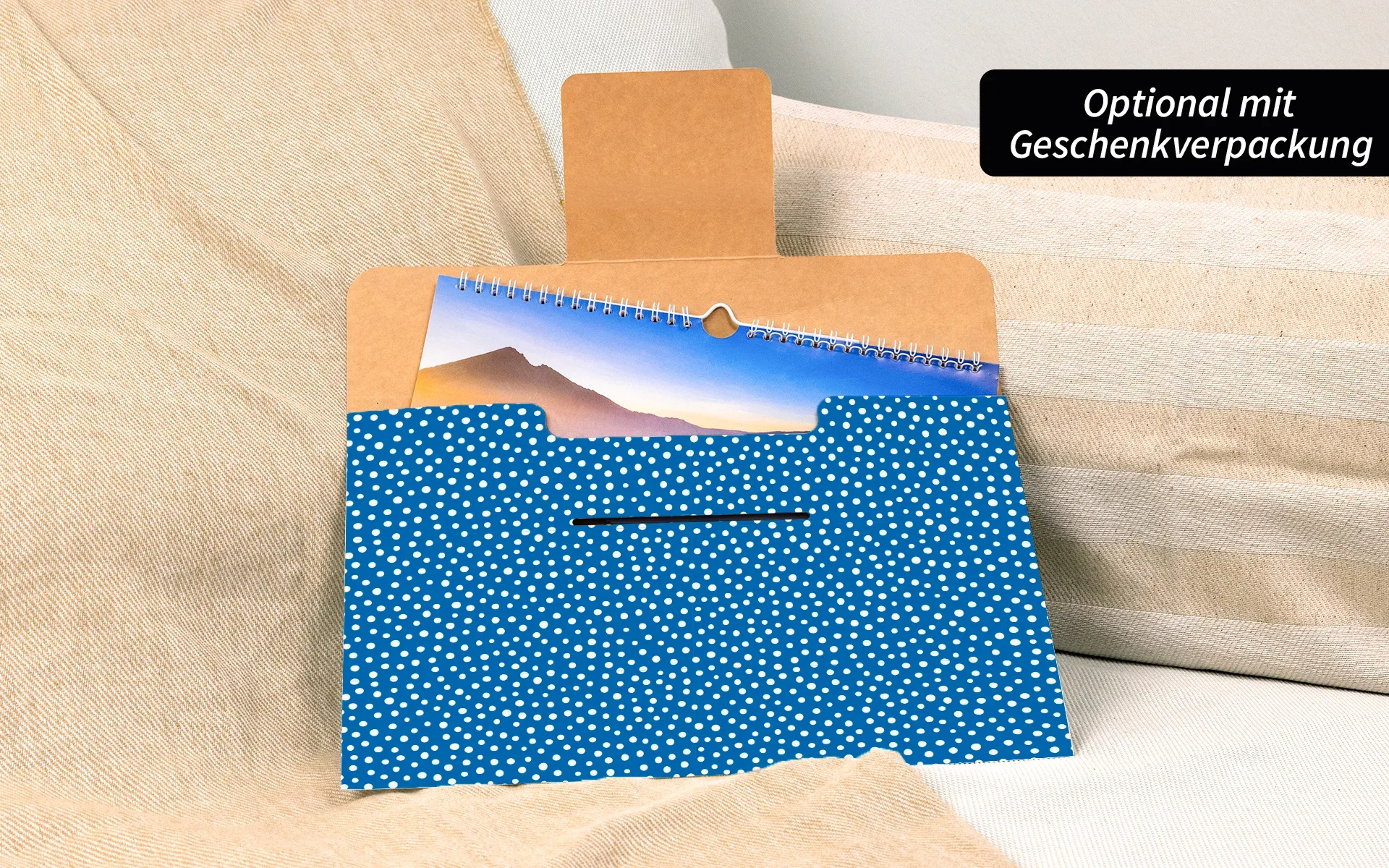 Ein HappyFotokalender in der neutralen Geschenkverpackung. Weiße Punkte auf blauem Hintergrund.