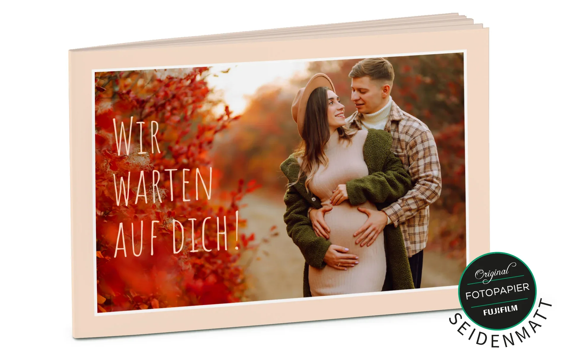 Ein aufgestelltes Happy Fotobuch ca. 13 x 19 cm mit dem Titel Wir warten auf dich zeigt ein Pärchen in einer herbstlichen Landschaft.