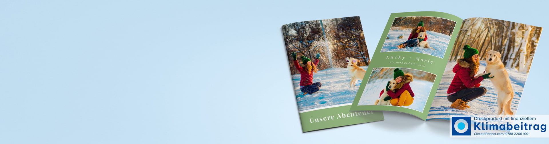 Zwei Frauen spielen im Schnee mit einem Hund in einem Fotobuch. Titel: