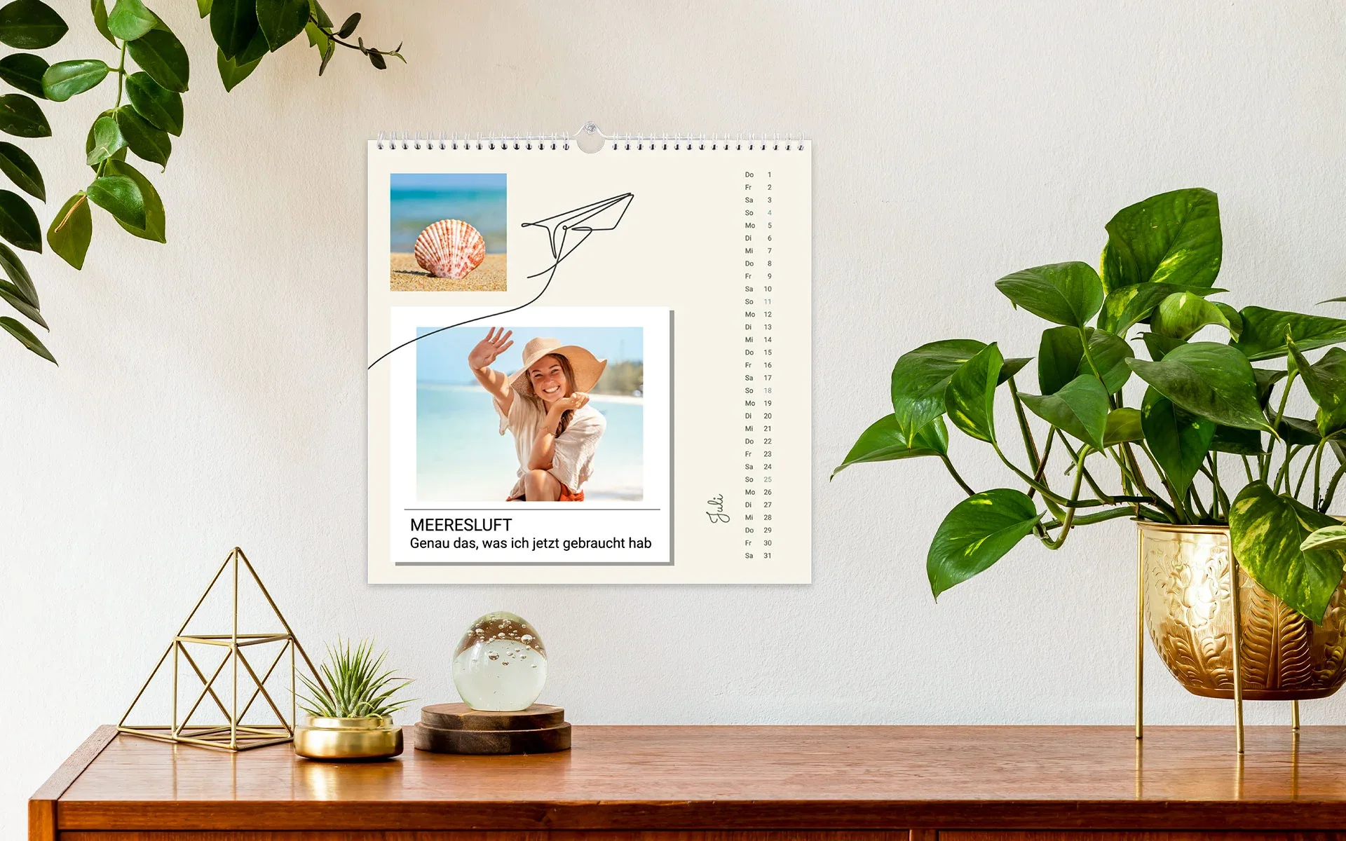 Ein aufgehängter HappyFotokalender ca. 21 x 21 cm mit dem Text Meeresluft zeigt eine junge Frau am Strand.